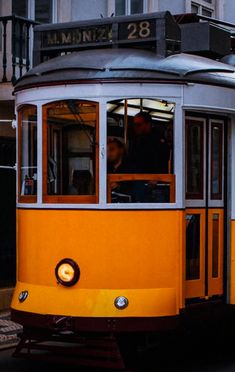 an orange and white trolley car traveling down the street