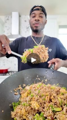 a man is holding a spoon full of rice and broccoli in a wok