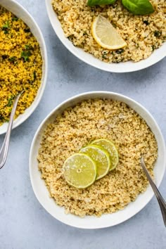 three white bowls filled with rice and topped with lemon slices, basil leaves and lime wedges