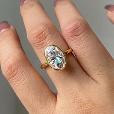 a woman's hand with a ring on it and a diamond in the middle