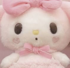 a close up of a stuffed animal with a bow on it's head and ears