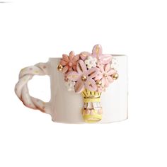 a white coffee cup with pink flowers on the inside and gold accents around the outside