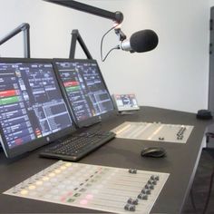 a laptop computer sitting on top of a desk next to a microphone and sound board