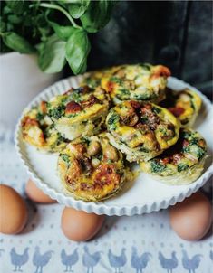 egg muffins with spinach and bacon on a plate next to some eggs