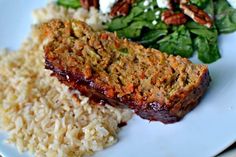 meatloaf, rice and spinach on a white plate with pecans in the background