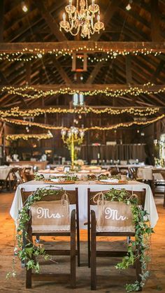 the tables are set up with white linens and greenery for an elegant reception