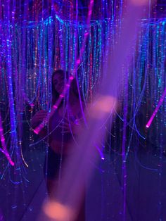 a woman standing in front of purple and blue lights