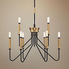 a black and gold chandelier with six candles hanging from the bottom to the top