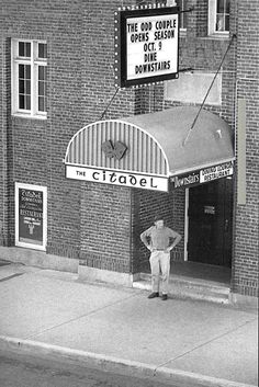 an old photo of a man standing in front of the citgoel theater