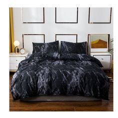 a bed with black and white comforter in a room next to two framed pictures