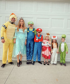 a group of people in costumes standing next to each other near a white garage door