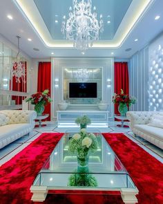 a living room with red carpet, white couches and a chandelier hanging from the ceiling