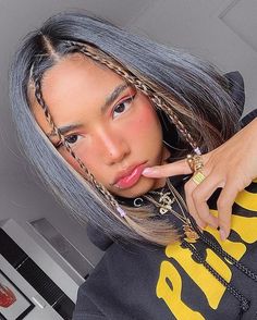 a woman with grey hair and braids on her head is posing for the camera