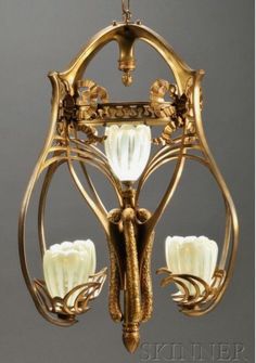 an antique chandelier with three lights hanging from it's center and two flowers on the bottom