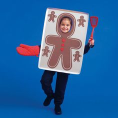 a child in a costume holding a red spatula and a sign with a gingerbread man on it