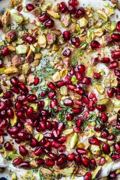 a pie with cranberries and pistachios on top is shown from above