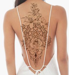 the back of a woman's body with tattoos on it