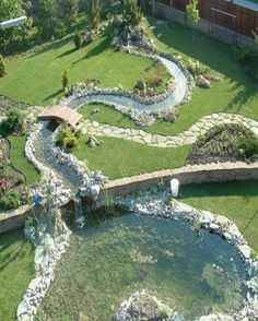 an aerial view of a garden with a pond and stone walkways in the center