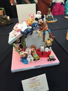 there is a cake made to look like mickey mouse and other disney characters on display