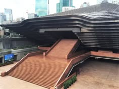 an empty wooden ramp in front of a building with tall buildings and skyscrapers behind it