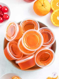 orange juice in plastic cups on a plate with cherries and cherry tomatoes around it