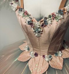 the back of a dress with flowers and sequins on it's skirt