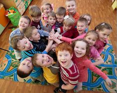 a group of young children standing next to each other on top of a wooden floor