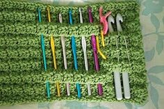 there are many different colored toothbrushes on the green crocheted cloths