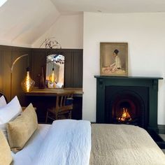 a bedroom with a fireplace, bed and desk in front of the fire place on the wall