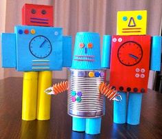 three toy robots sitting on top of a wooden table