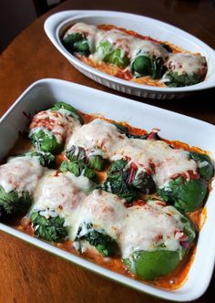 two white casserole dishes filled with broccoli covered in cheese and sauce