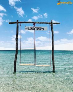 a sign that reads lagoa bonita hanging from a wooden frame in the ocean