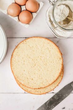 bread, eggs and flour on a white countertop next to a pair of scissors