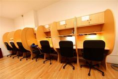 a row of office chairs sitting next to each other on top of a hard wood floor