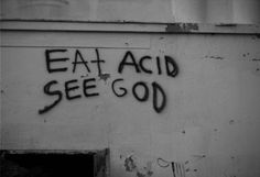 graffiti on the side of a building that says eat acid see god in black and white