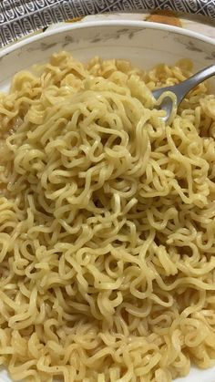 a white bowl filled with noodles on top of a table