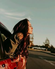 a woman leaning out the window of a car