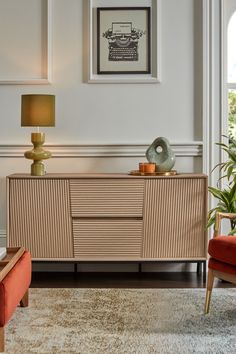 a living room with a couch, chair and sideboard