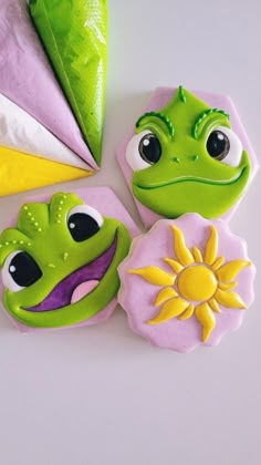 some cookies that are shaped to look like frogs and sunflowers on a table