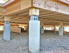 an unfinished building with concrete pillars and wooden posts