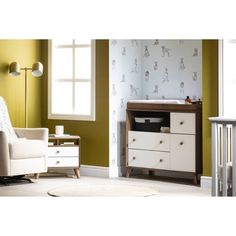 a baby crib in the corner of a room with green walls and white furniture