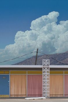 a stop sign in front of a building with mountains in the background