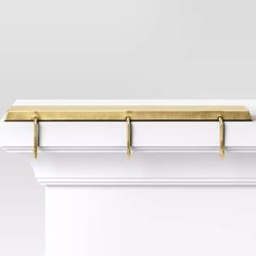 a white and gold shelf with two brass handles