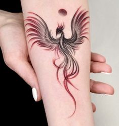 a woman's arm with a bird tattoo on it