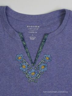 a purple shirt with blue flowers on it and a necklace that says sonoma in the center