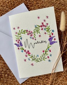 a mother's day card with the word mum written on it and flowers in the shape of a heart