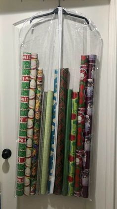 several rolls of wrapping paper are hanging on a door handle with a clear cover over them