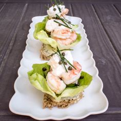 three white plates topped with lettuce and shrimp on top of eachother