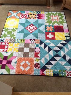 a patchwork quilt on the floor in a living room