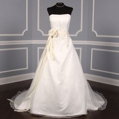 a white wedding dress on display in a room